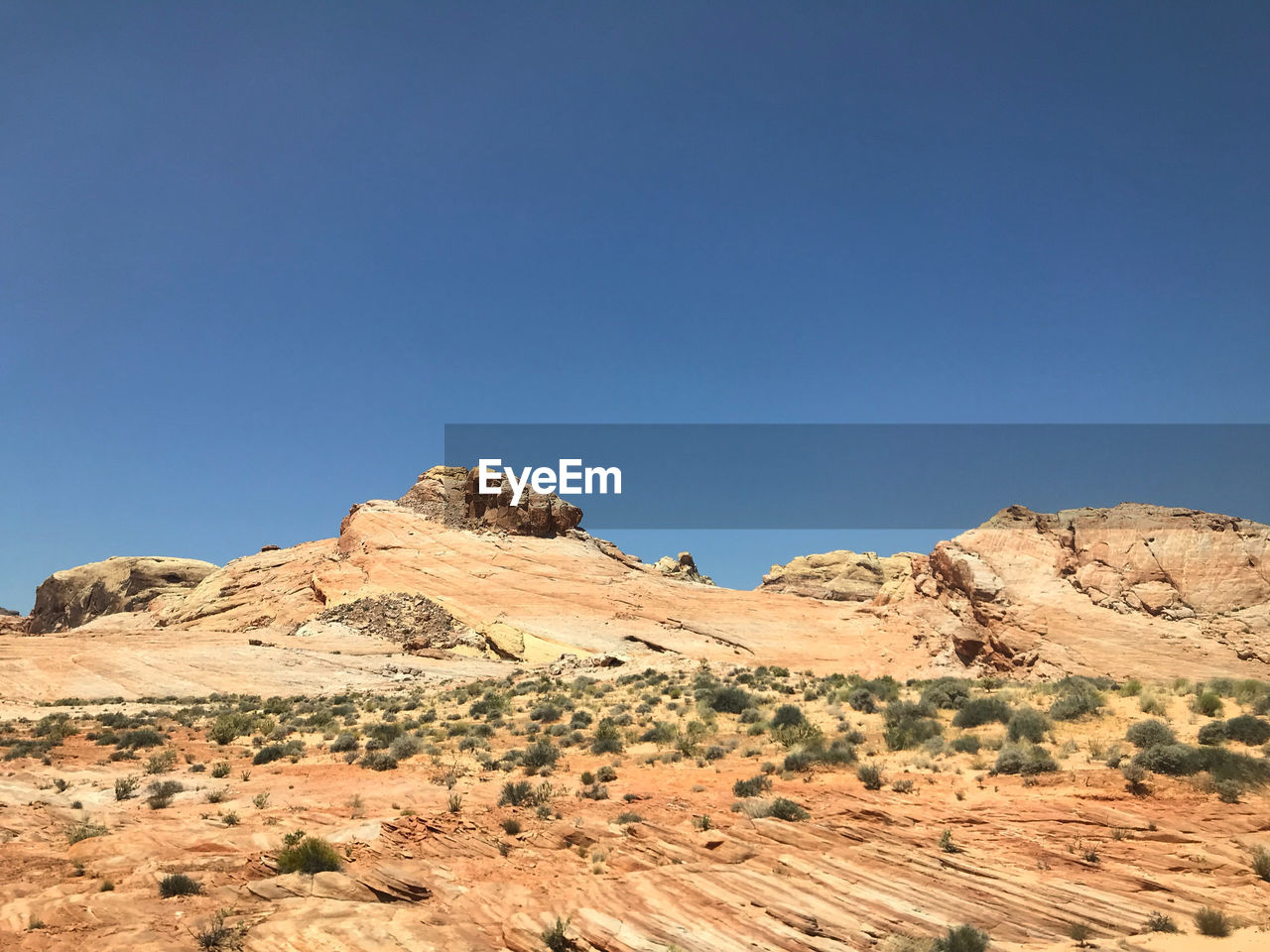 Scenic view of desert against clear blue sky