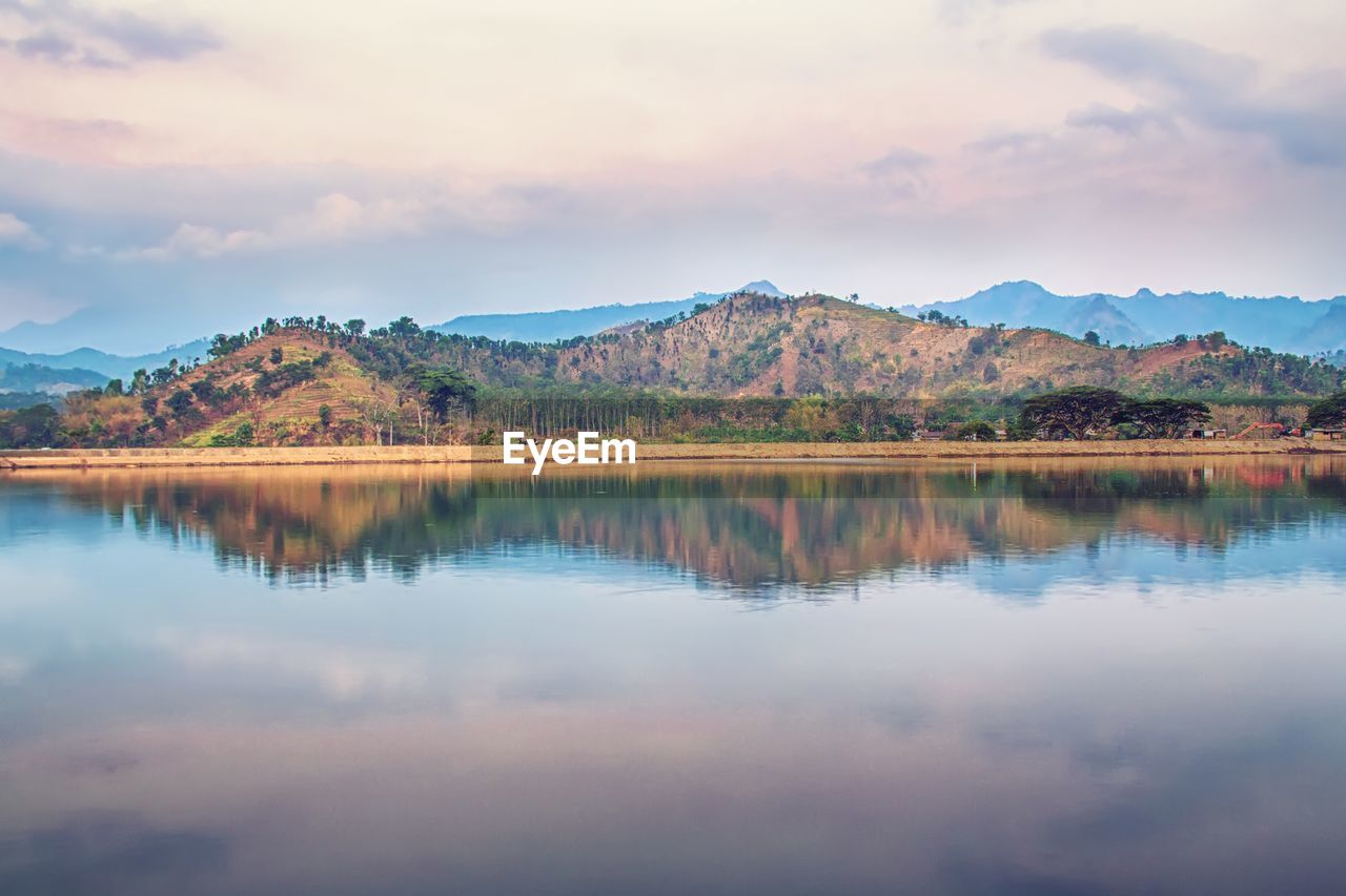 Scenic view of lake by mountains against sky