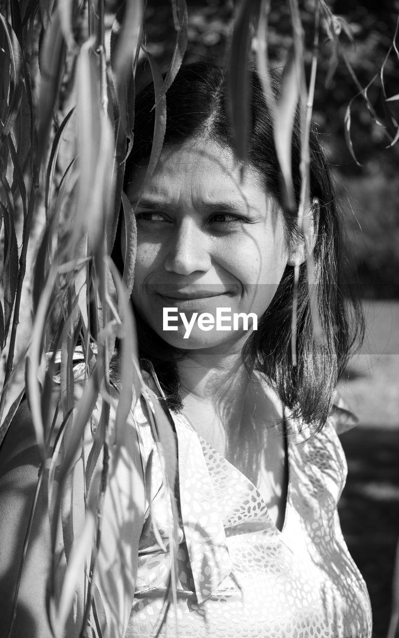 portrait, black and white, women, one person, monochrome photography, black, monochrome, female, headshot, plant, adult, smiling, looking at camera, child, nature, childhood, white, front view, portrait photography, emotion, young adult, lifestyles, tree, day, outdoors, hairstyle, happiness, leisure activity, long hair, photo shoot, person, sunlight, casual clothing