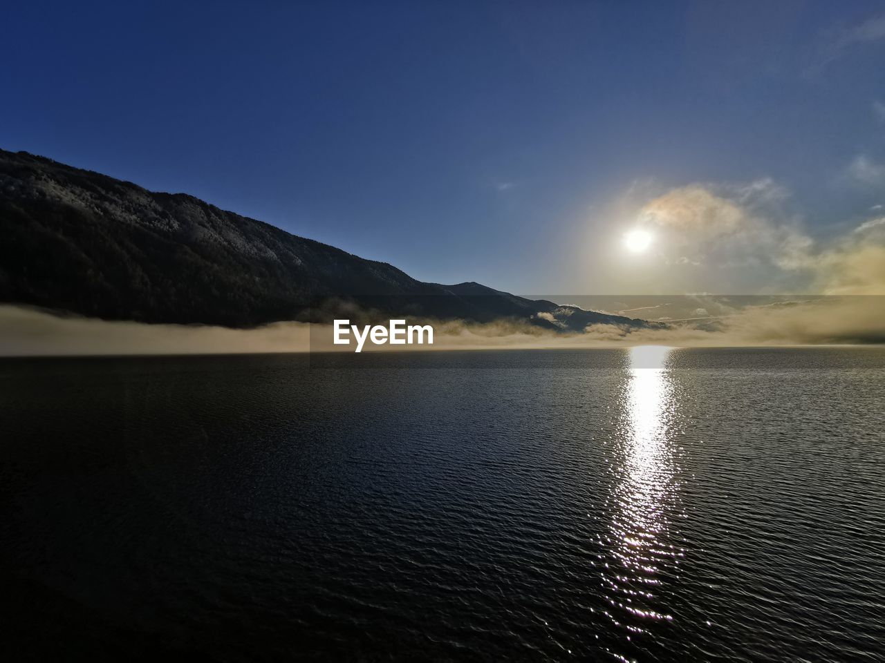 SCENIC VIEW OF SEA BY MOUNTAIN AGAINST SKY DURING SUNSET