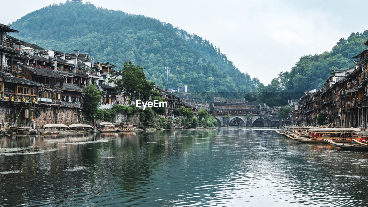 Bridge over river amidst buildings against sky