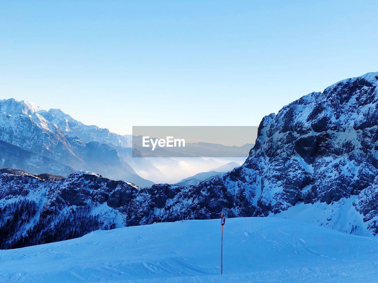 Scenic view of snowcapped mountains against clear blue sky