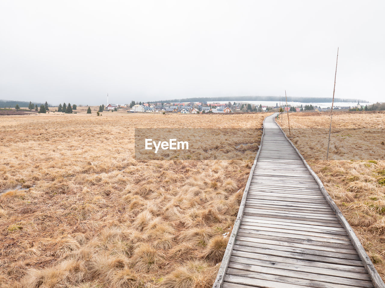 land, sky, walkway, landscape, nature, beach, water, boardwalk, environment, sea, scenics - nature, field, tranquility, tranquil scene, wood, shore, horizon, beauty in nature, day, sand, no people, architecture, travel destinations, the way forward, non-urban scene, coast, copy space, agriculture, urban skyline, outdoors, rural scene, built structure, pier, travel, absence, overcast, plant, transportation, diminishing perspective, tourism, clear sky, trip, empty, horizon over water, idyllic, holiday, vacation, coastline, grass, footpath, summer, cloud