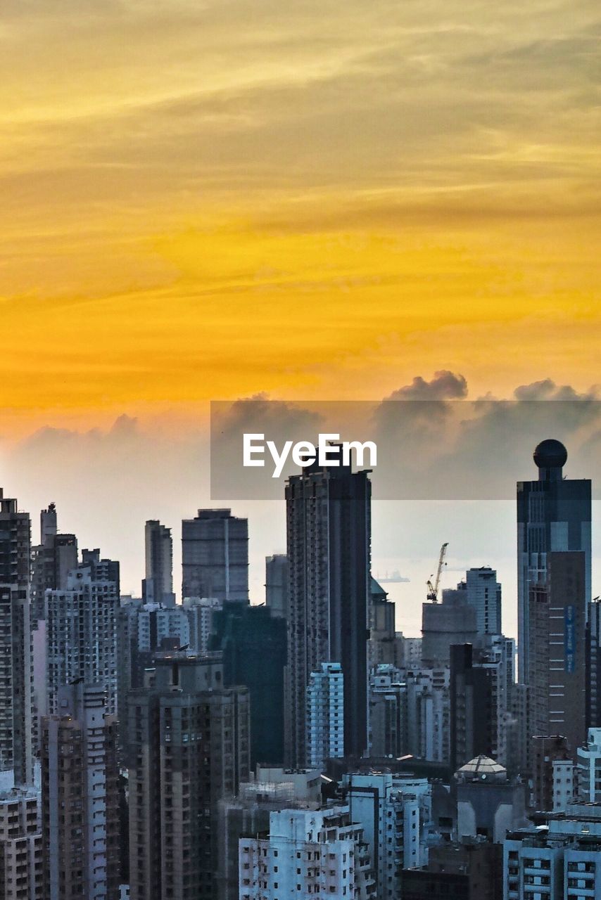 View of cityscape against cloudy sky during sunset