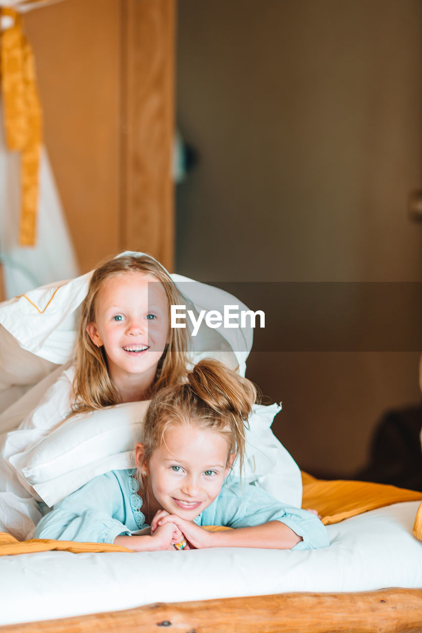 Portrait of smiling girl lying on bed