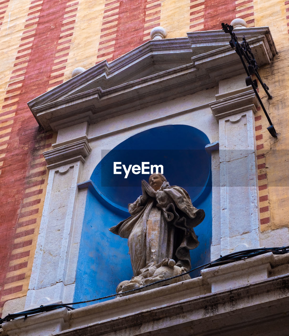 LOW ANGLE VIEW OF STATUE BY BUILDING