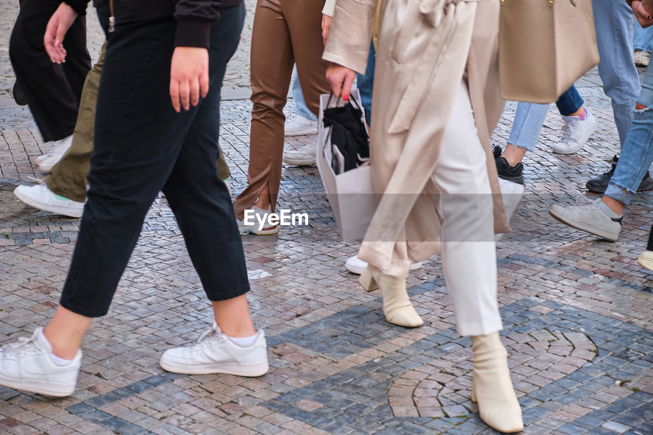 low section of people walking on road