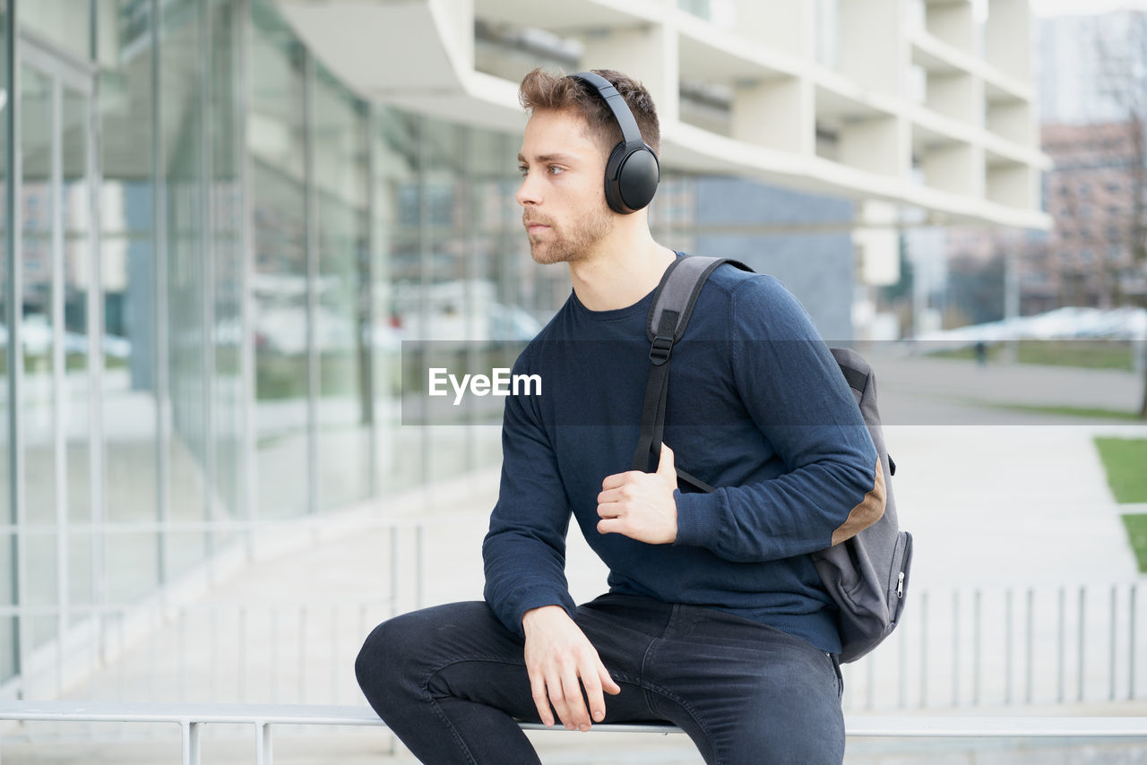 Young man with headphones on city street