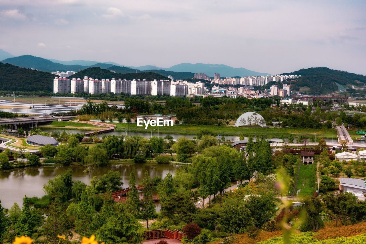 High angle view of townscape by lake against sky