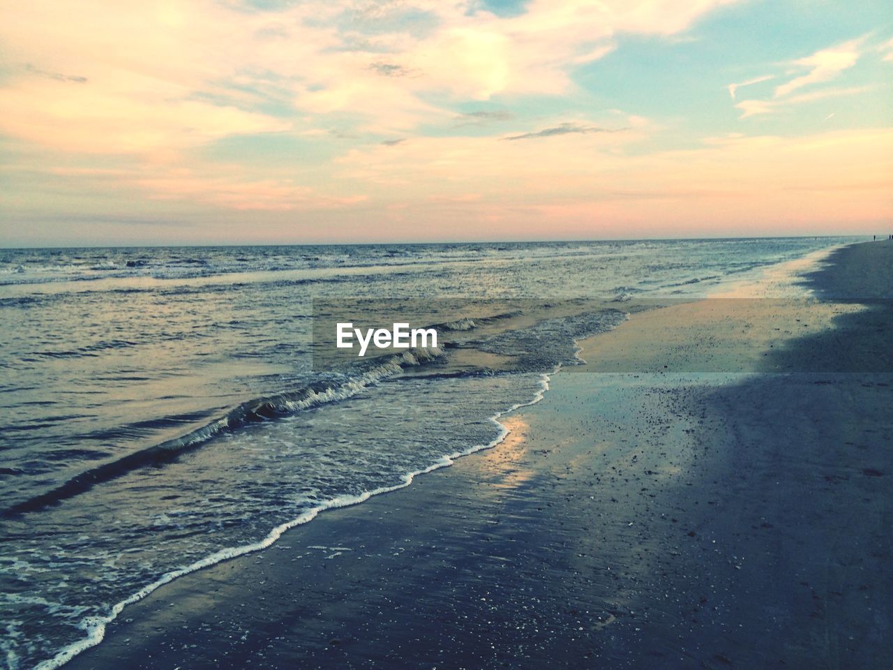 SCENIC VIEW OF BEACH AGAINST SKY AT SUNSET