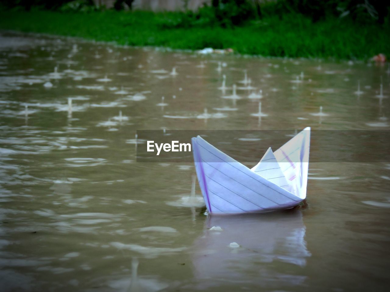 Paper boat in puddle during rainy season