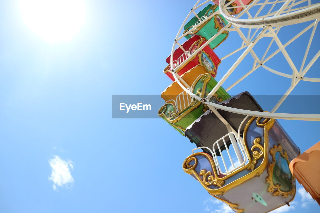 low angle view of man holding illuminated ferris wheel against sky