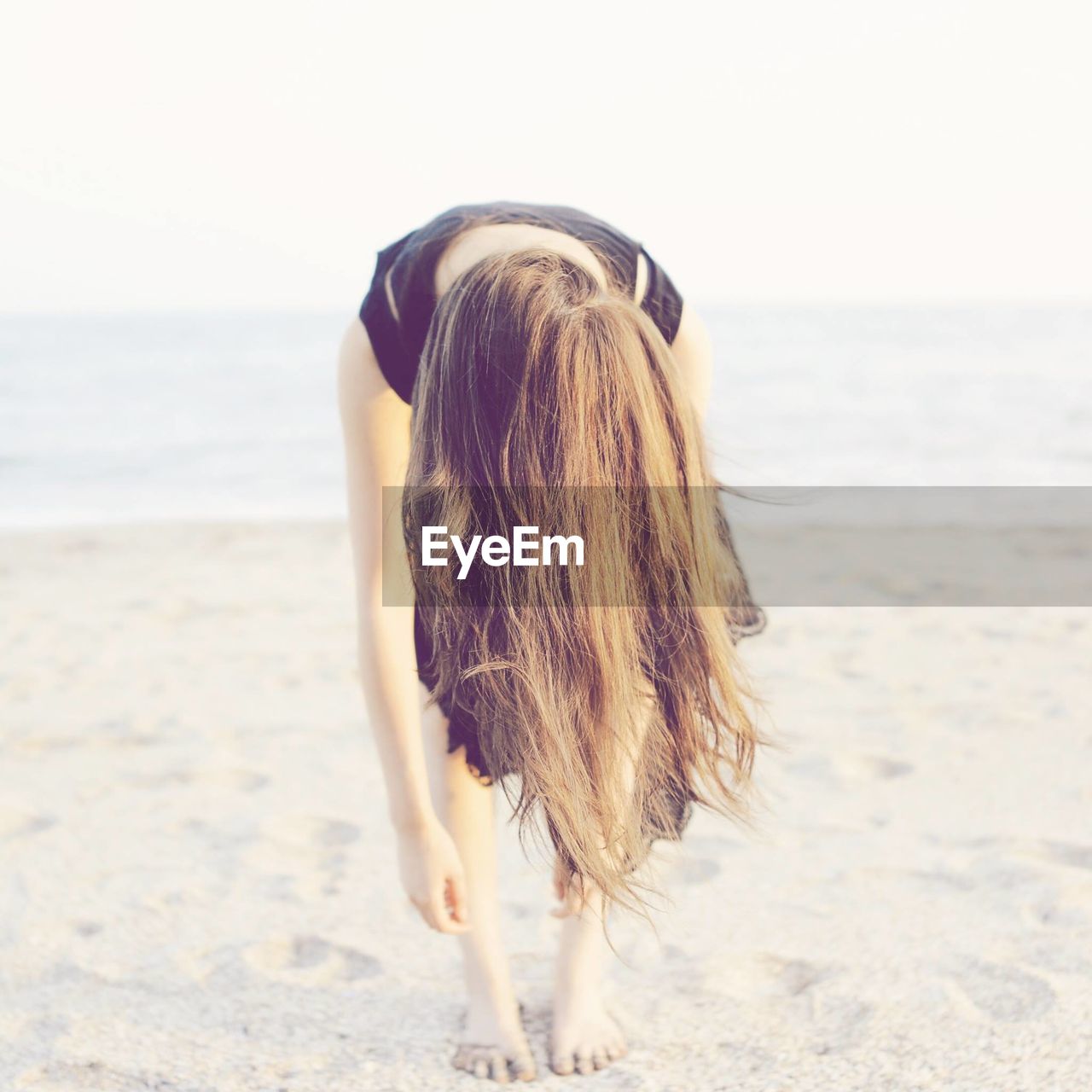 Young woman stretching on beach