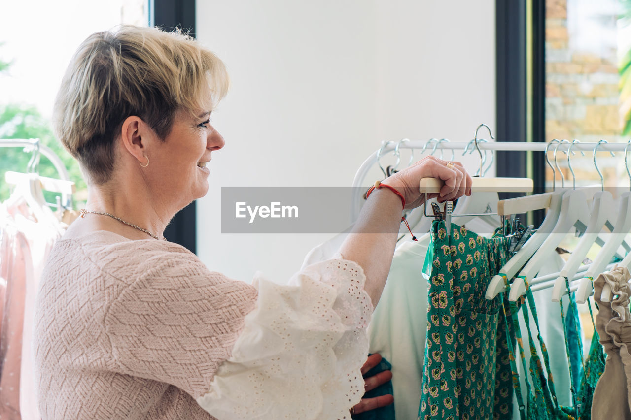 Mature woman choosing clothes at store