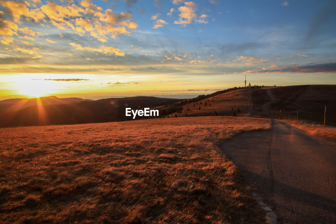 SCENIC VIEW OF SUNSET OVER FIELD