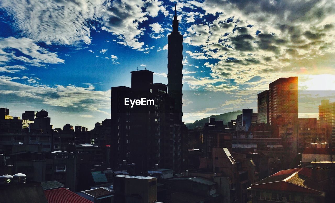 Low angle view of taipei 101 and buildings against cloudy sky