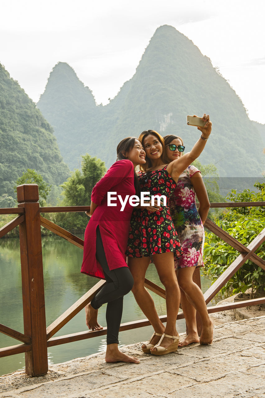 Three female friends taking selfie at river li close to yangshuo