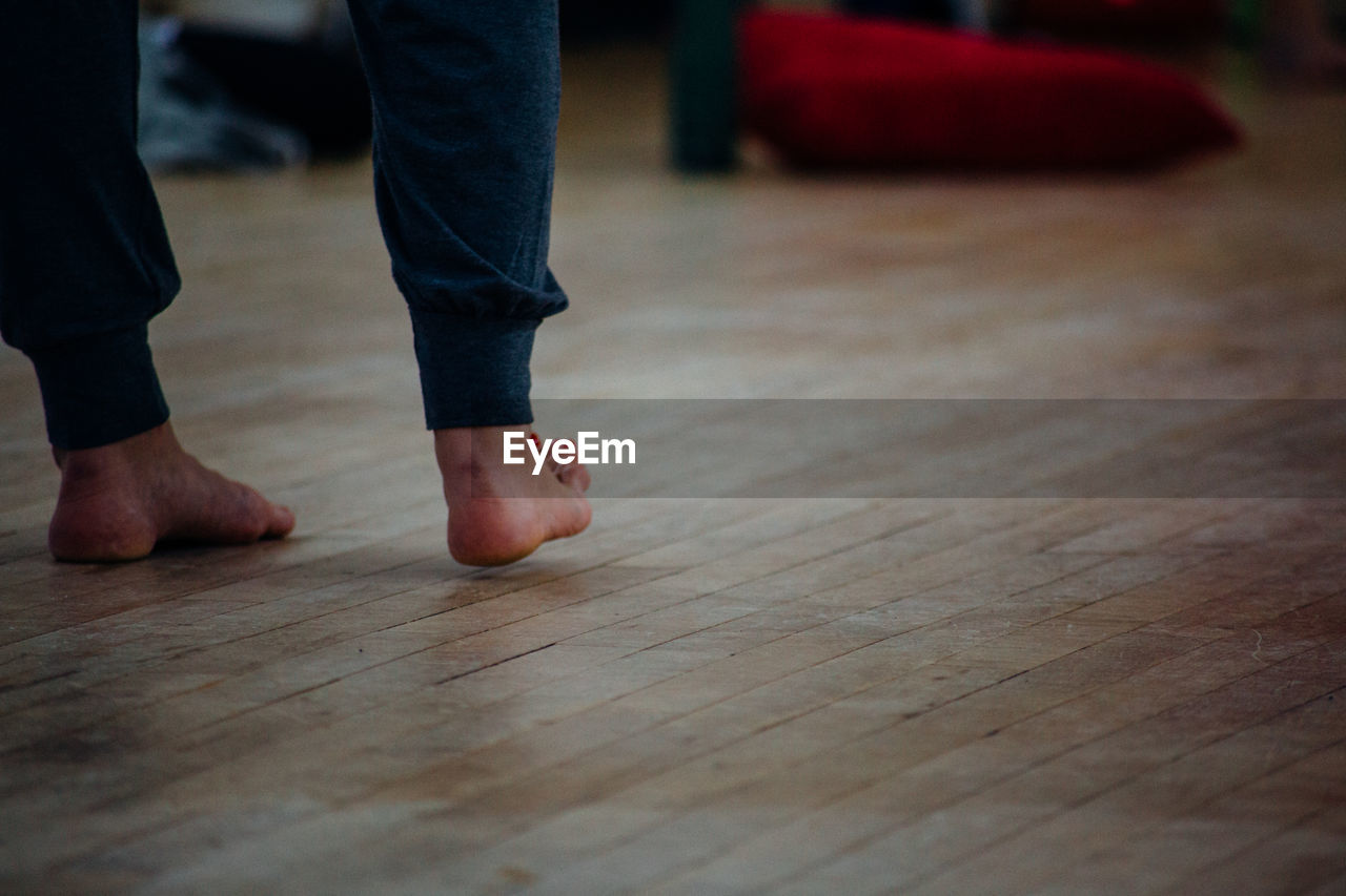 Low section of woman standing on hardwood floor