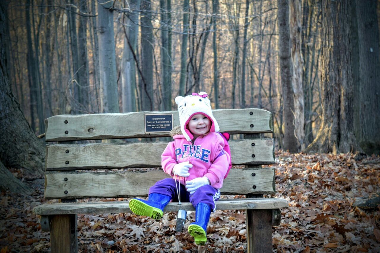 PORTRAIT OF CUTE GIRL STANDING ON WOODEN WALL