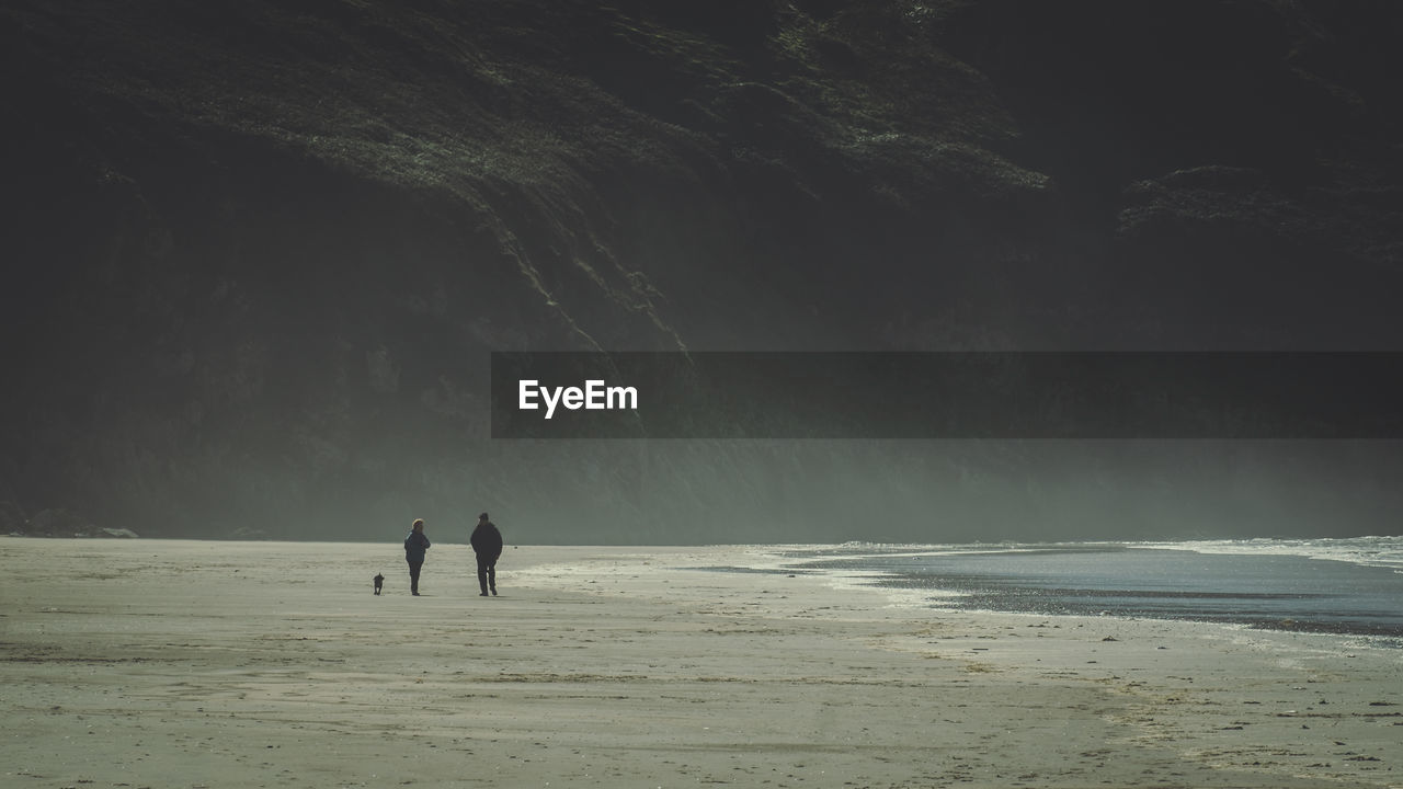 People walking on beach against sky