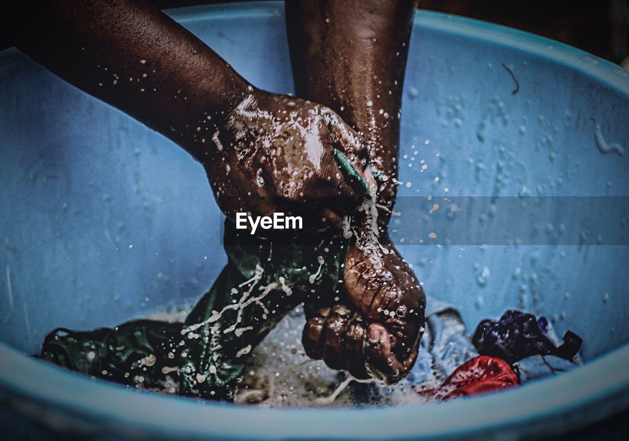 Cropped image of hands washing clothes