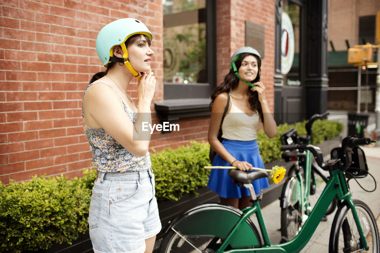 Friends wearing helmet at sidewalk cafe