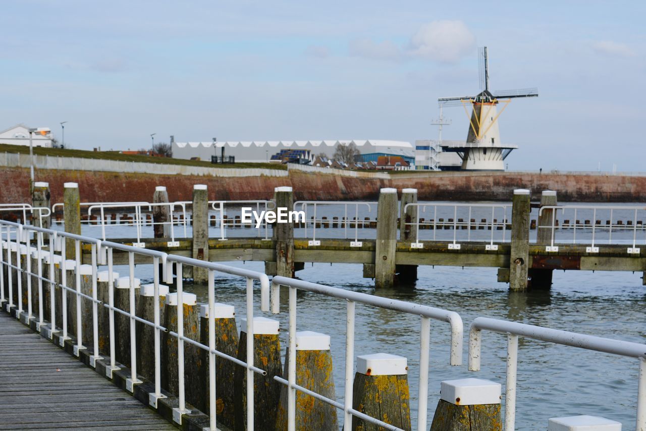 WOODEN POSTS IN RIVER AGAINST SKY