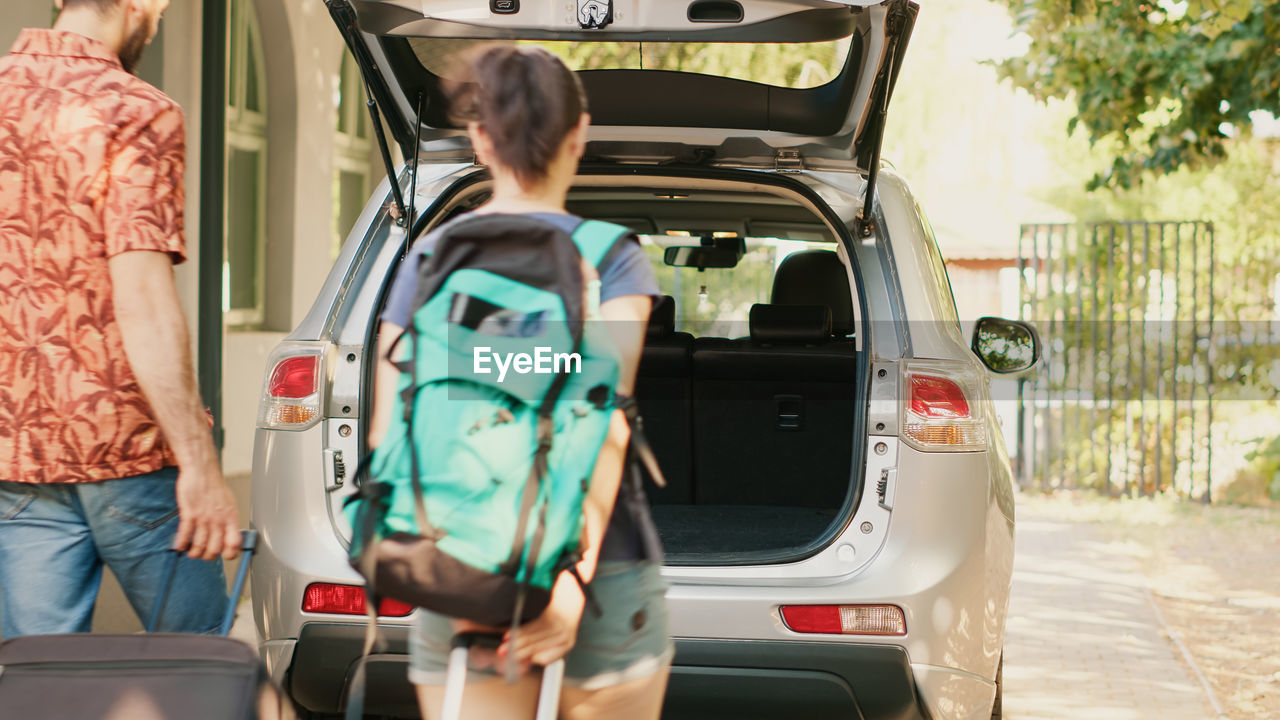 rear view of woman standing by car