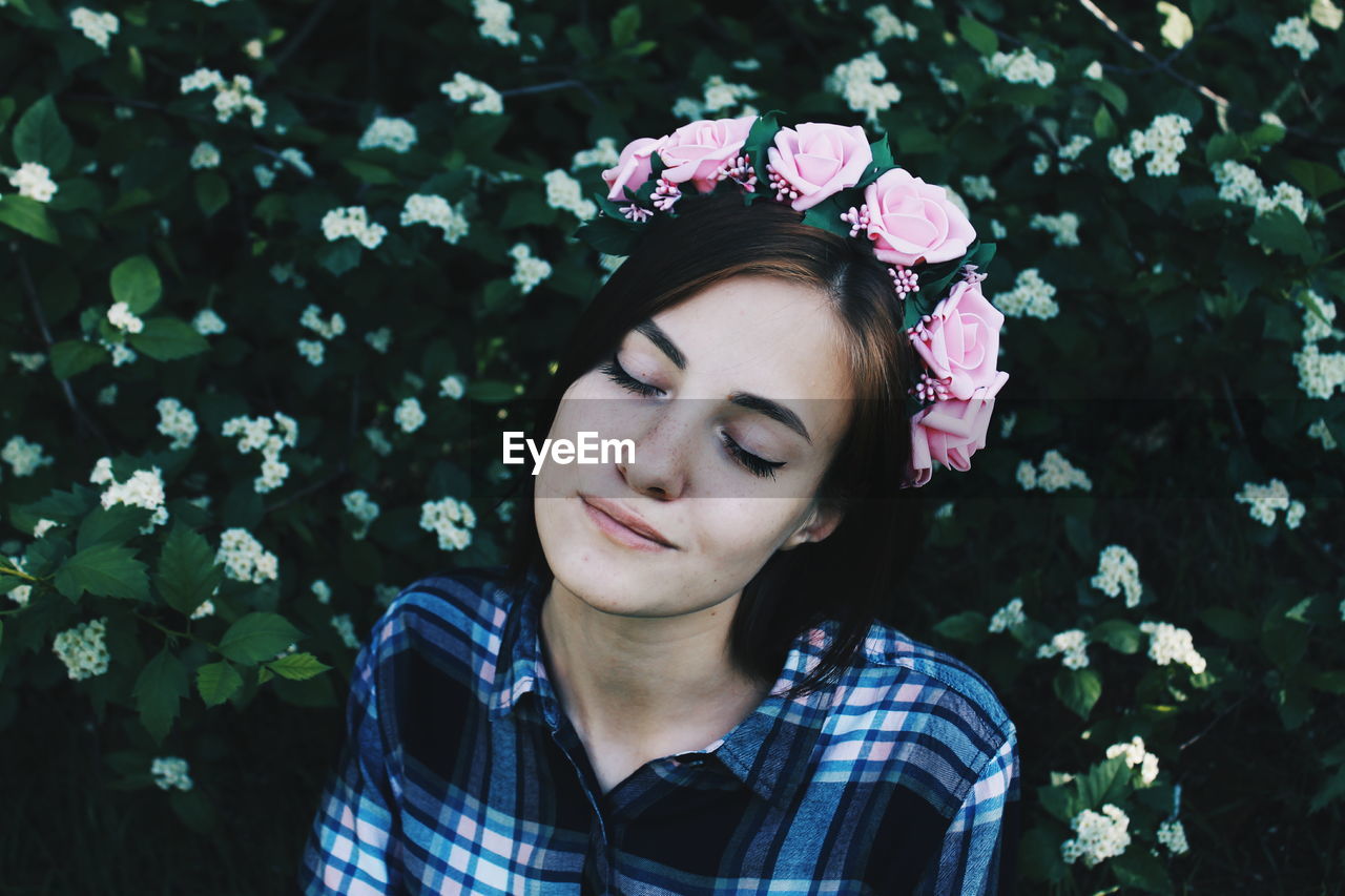 Close-up of young woman with flowers in park