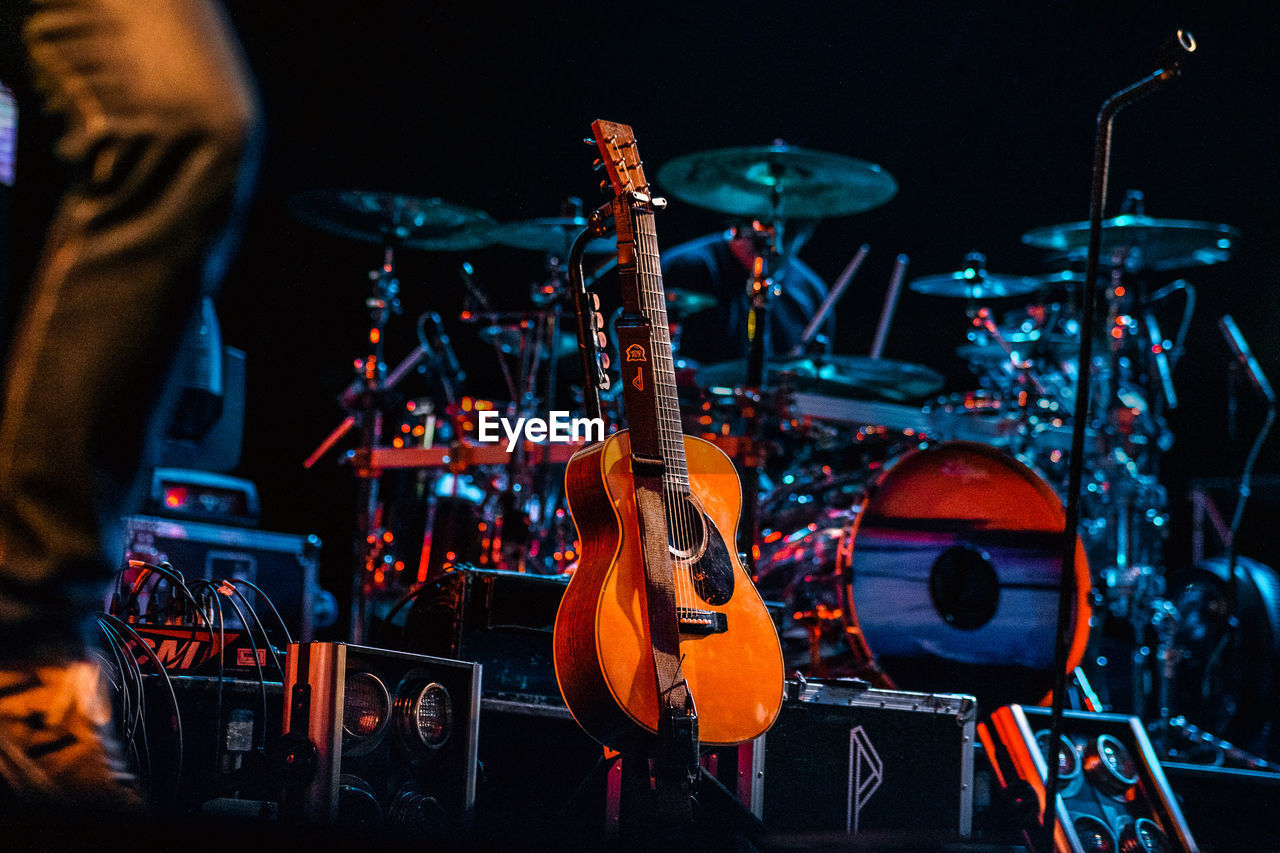 CLOSE-UP OF GUITAR IN ILLUMINATED STAGE