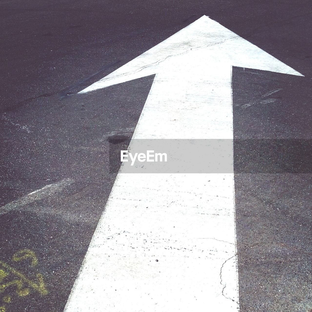 Close-up of arrow symbol on asphalt road