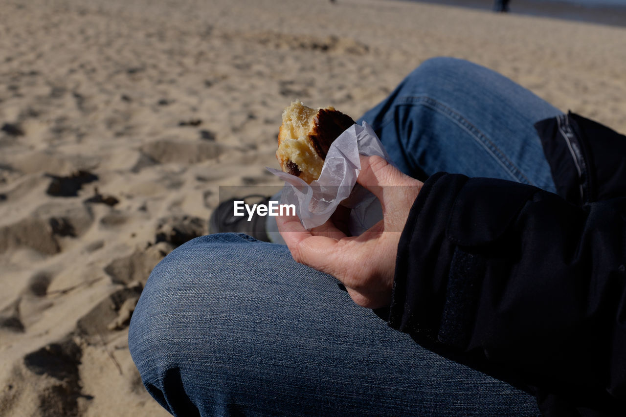 LOW SECTION OF PERSON EATING FOOD