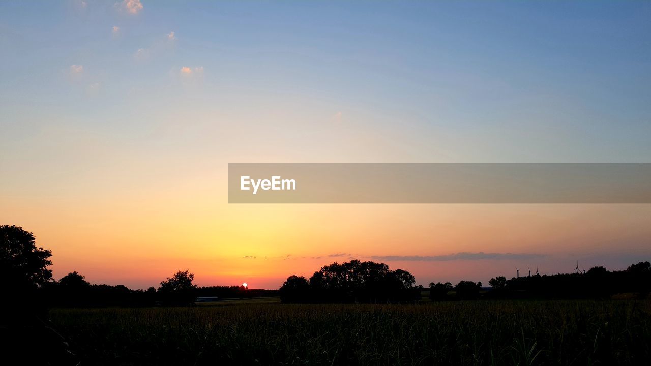 SCENIC VIEW OF SUNSET OVER FIELD