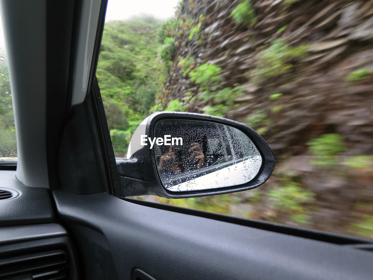 CLOSE-UP OF SIDE-VIEW MIRROR ON CAR