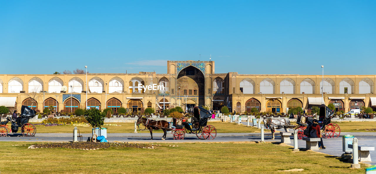 GROUP OF PEOPLE IN FRONT OF BUILT STRUCTURE