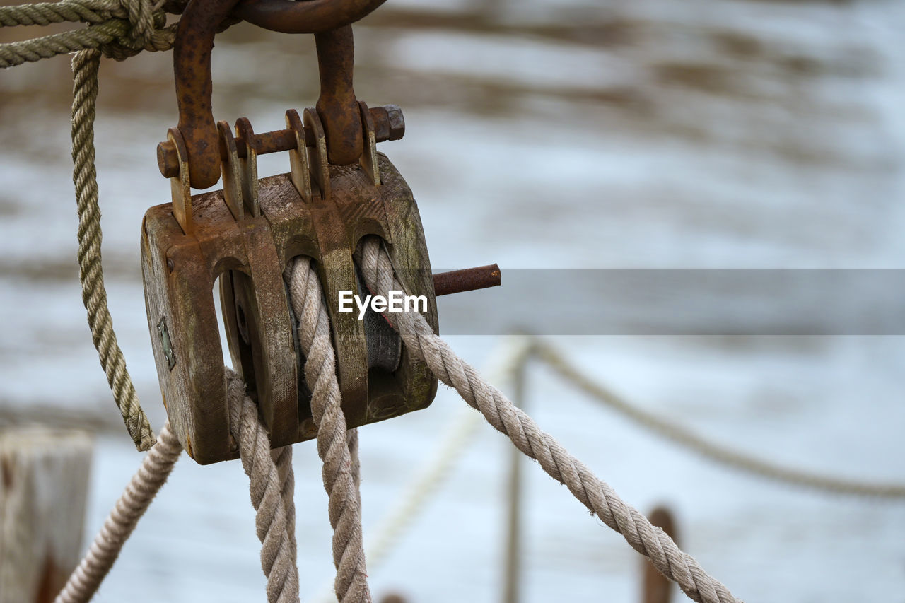 CLOSE-UP OF ROPE TIED UP ON RUSTY METAL