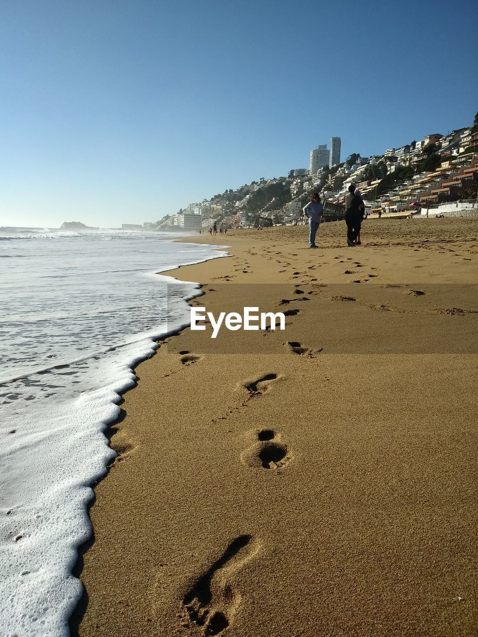 FOOTPRINTS ON SANDY BEACH AGAINST CLEAR SKY