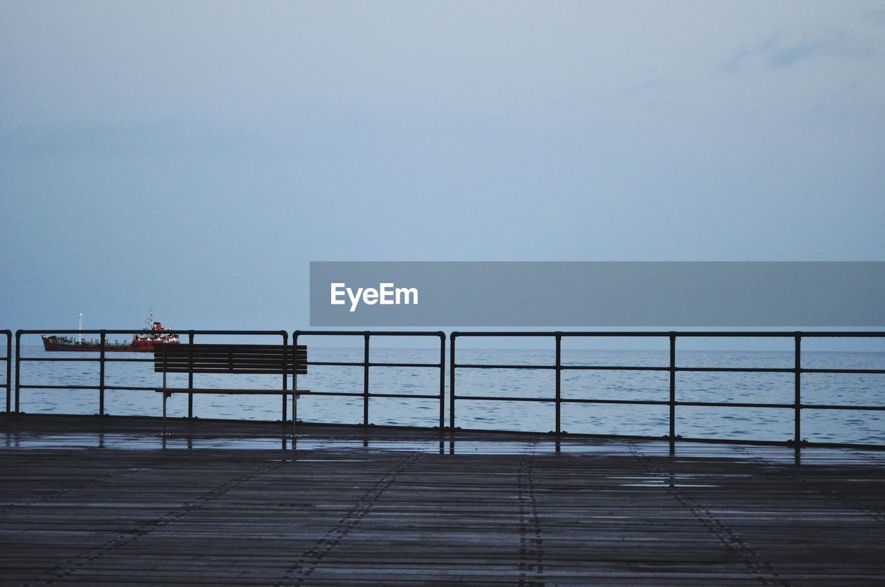 View of pier with ship on sea on background