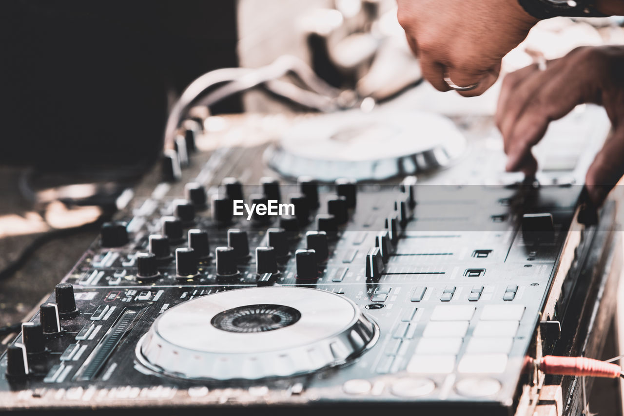 Cropped hands of musician adjusting sound mixer