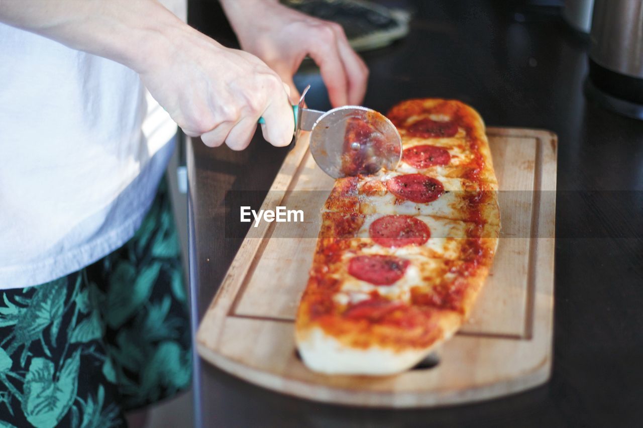 Midsection of man holding pizza