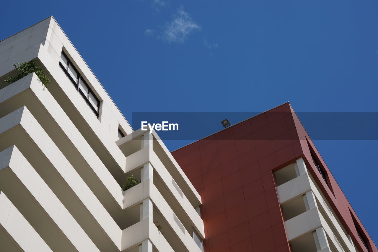 Low angle view of modern building against clear blue sky