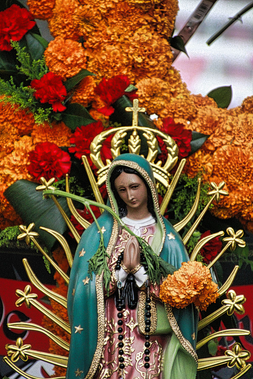 Close-up of virgin mary against flowers at church