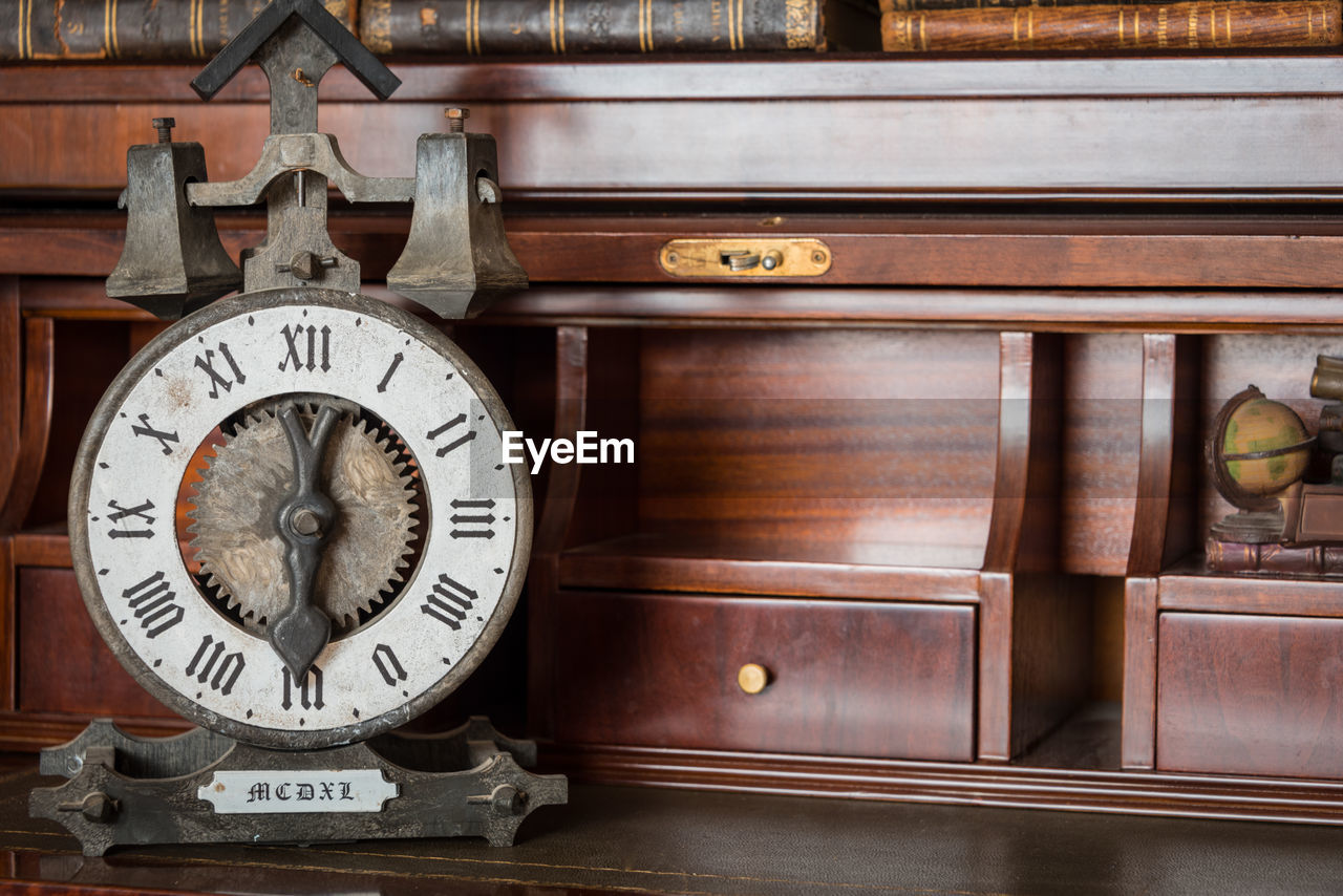 CLOSE-UP OF OLD CLOCK ON WOODEN WALL