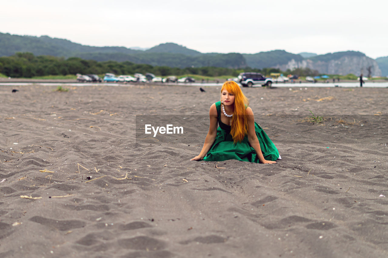 Beautiful woman kneeling at beach