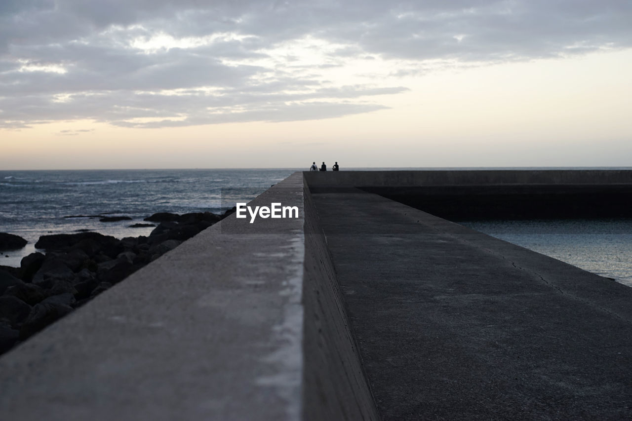 Surface level of pier on sea against sky