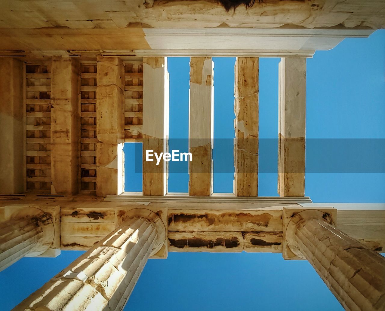 Directly below view of ceiling acropolis against clear blue sky