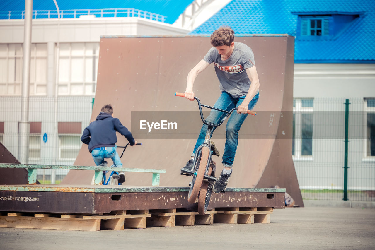 Friends riding bicycles at playground in city