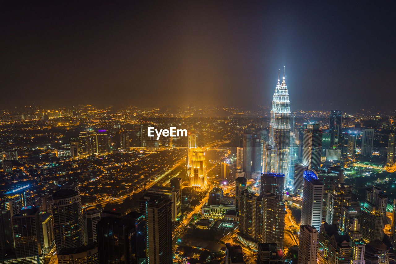 Aerial view of illuminated city buildings at night