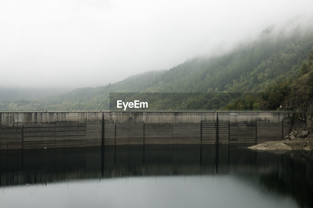 Scenic view of lake against sky during foggy weather