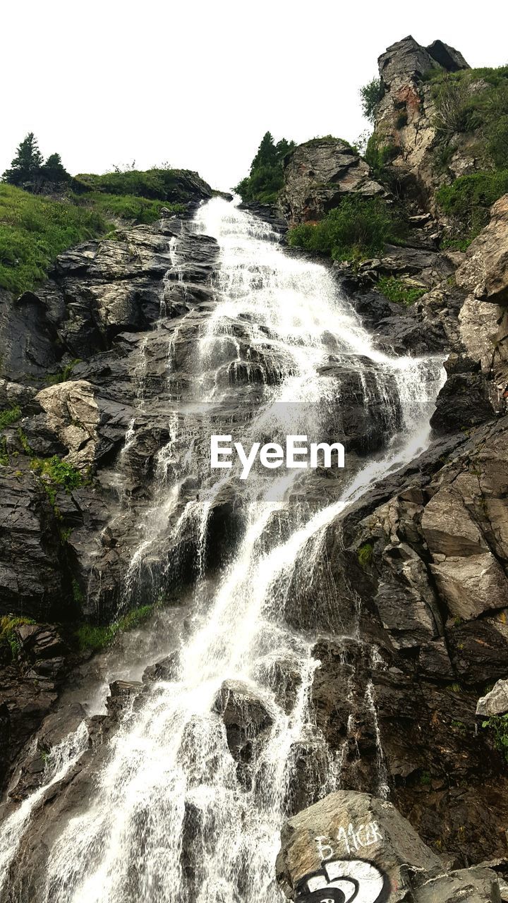 Scenic view of waterfall against sky